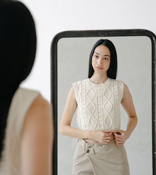 lady looking at herself in the mirror wearing casual clothes